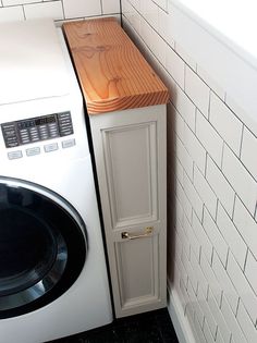 a washer and dryer in a small room with white tiles on the walls