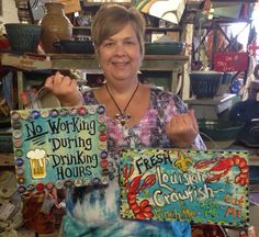 a woman holding up two signs in her shop