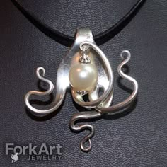 an octopus pendant with a pearl in it's mouth