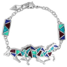 The silver-toned bracelet features three running horse silhouettes at the top of the bracelet. A geometric pattern brings color to the design. Dark red, bright turquoise, vivid navy, and deep blue colored stones are all held together and laid with silver tones. Materials: Rhodium and rose gold over a brass base. Synthetic blue turquoise and blue green turquoise. Red agate. Blue lapis. Montana Silversmith Jewelry, Western Bracelets, Horse Bracelet, Running Horse, Horse Silhouette, Western Belt Buckles, Western Earrings, Bright Turquoise, All The Pretty Horses