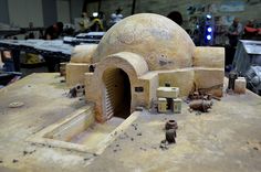 a model of a stone oven with people standing around it