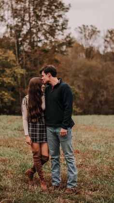 a man and woman standing next to each other in a field