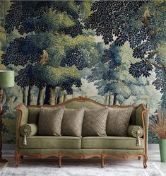 a green couch sitting in front of a forest wallpaper