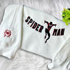 Introducing our Miles Morales Embroidered Crewneck T-Shirt, a must-have for all Marvel fans! Made with high-quality materials, this sweatshirt offers supreme comfort and durability. With its eye-catching Miles Morales embroidery, you’ll stand out from the crowd and showcase your love for the iconic superhero. Available for both men and women, this shirt is versatile and stylish, perfect for any occasion. Whether you’re heading to a comic convention or simply lounging around, this swe Spiderman Shirt, Toy Story Shirt, Hawaiian Shirt Women, Cartoon Sweatshirts, Embroidered Crewneck, Miles Morales, Sweatshirt For Men, Embroidered Clothes, Embroidered Sweater