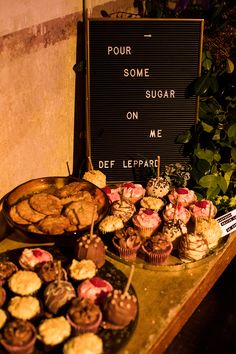 a table topped with lots of cupcakes and muffins