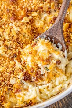 a casserole dish filled with macaroni and cheese topped with a wooden spoon