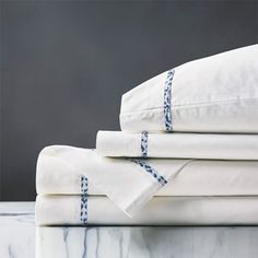 four white sheets folded on top of each other in front of a gray background with blue trim