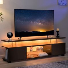 a flat screen tv sitting on top of a wooden entertainment center in a living room