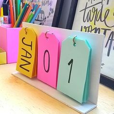 colorful desk calendars with the numbers one and two on them sitting on a desk