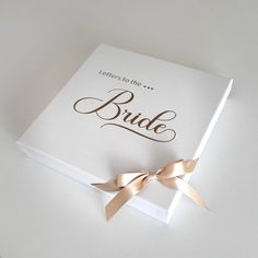 a white box with a gold bow on it that says, letters to the bride