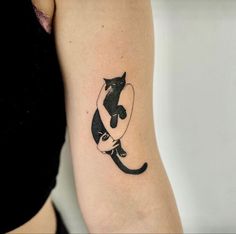 a black and white cat tattoo on the arm