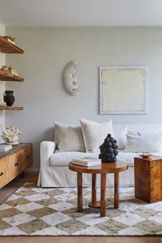 a living room with a couch, coffee table and bookshelf on the wall