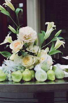 white flowers and green apples on a table