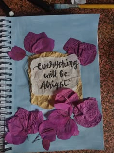 a notebook with writing on it and purple flowers