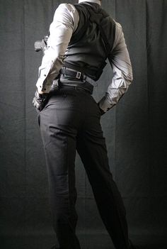 a man dressed in black and white is standing with his back turned to the camera