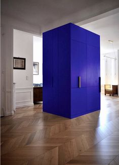 an instagram photo of a blue cube in the middle of a room with wood floors