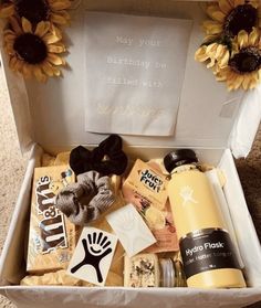 an open box with sunflowers and other items in it