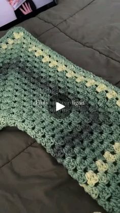 a crocheted blanket laying on top of a bed