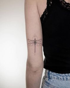 a woman with a dragonfly tattoo on her arm