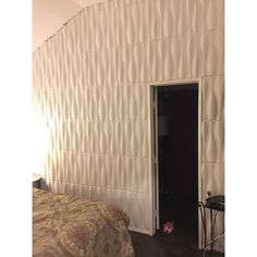 a bed room with a neatly made bed next to a wallpapered headboard