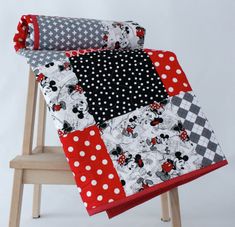 two mickey mouse quilts are sitting on top of a chair and one is red, white, and black