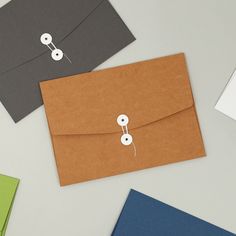 three different colored envelopes with buttons on them