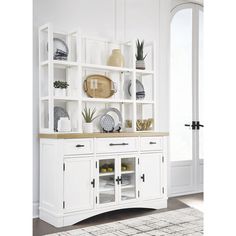 a white cabinet with glass doors and shelves filled with plates, vases and plants