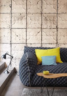 a living room with a couch, table and lamp on the floor next to it