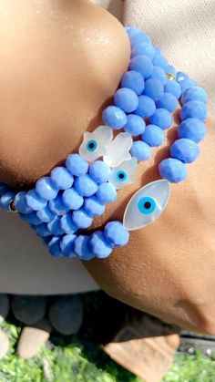 6mm Blue Briolette Crystal Faceted Beads Mother of Pearl Hamsa Hand White  Mother Of Pearl Hamsa Hand With Blue Evil Eye Handmade  Made to order  6mm High Quality Stretch String Bracelet   Please include in message size of wrist & the number of which bracelet you prefer. Example : Wrist 6.5 #2 Blue Evil Eye, String Bracelet, Hamsa Hand, Blue Crystals, Faceted Bead, Bracelet Designs, Evil Eye, Mother Of Pearl, Halloween Shopping