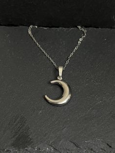 Crescent moon necklace hangs on stainless steel chain approx 18" Moon Phase Metal Necklace In Moon Shape, Moon Shaped Metal Necklace With Adjustable Chain, Moon-shaped Metal Necklace With Adjustable Chain, Moon Phase Necklace In Metal, Metal Moon Phase Necklace, Half Moon Metal Necklace For Gift, Half Moon Metal Necklace For Gifts, Silver Moon Shaped Metal Necklace, Nickel Free Silver Moon Necklace