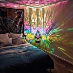 a bed room with a neatly made bed and colorful lights on the wall behind it