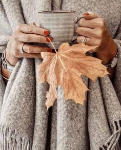 a woman holding a coffee cup and a leaf