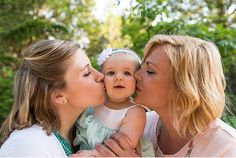 two women and a baby are kissing each other