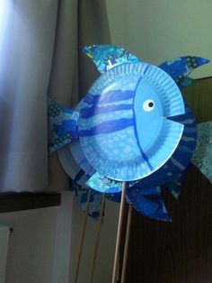 a paper plate fish on top of a stick