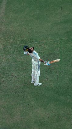 a man holding a cricket bat on top of a field