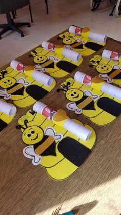 several yellow and black bees are on top of the wooden table with crayons