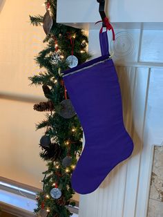 a purple christmas stocking hanging from the side of a fireplace