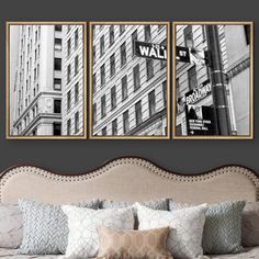 two black and white pictures hanging on the wall above a bed in front of a city street sign