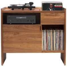 an old record player is sitting on top of a wooden cabinet with vinyl records in it