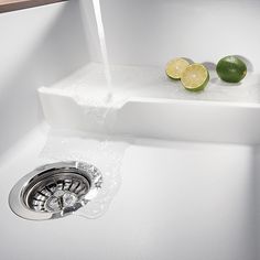 two limes are sitting on the edge of a sink