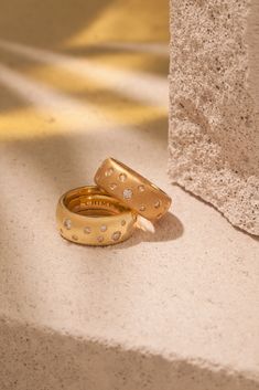 two gold wedding rings sitting on the ground