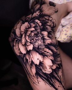 a woman's thigh with black and white flowers on it