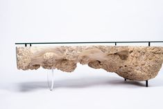 a table that has some kind of rock on it with glass top and metal legs