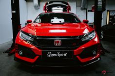 the front end of a red sports car in a garage