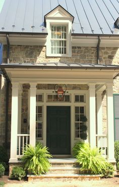 the front door of a house with two plants on either side