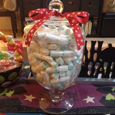 a glass jar filled with candy on top of a table