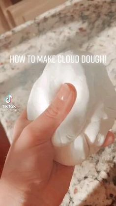 a hand holding a doughnut with the words how to make cloud dough on it