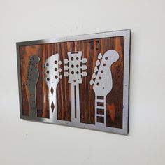 Elevate your space with our Guitar Headstock Metal Art on Wood Wall Decor. This exquisite piece beautifully combines the artistry of a guitar headstock with the rustic charm of wood. Handcrafted with precision, this unique metal art is a must-have for music lovers and those who appreciate musical decor. It serves as a striking wall hanging that adds a touch of elegance to your surroundings. Hang it proudly to showcase your passion for music or gift it to someone who shares your love for melodies Musical Decor, Guitar Headstock, Guitar Wall, Art On Wood, Metal Words, Handmade Artwork, Wood Wall Decor, Cool Guitar, Wall D