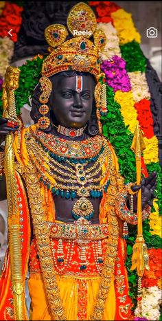 an idol is displayed in front of a flower arrangement