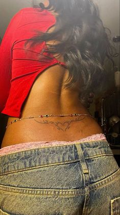 the back of a woman's body with tattoos on her lower back and side